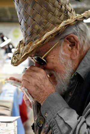 man in hat studying coin